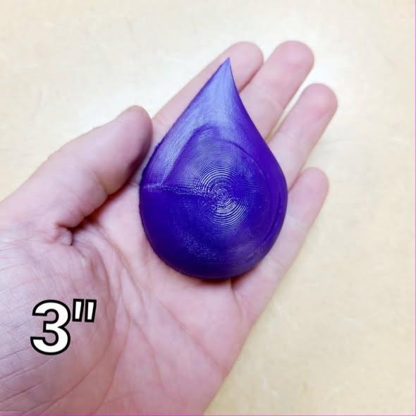 Deep purple resin teardrop cast held in a palm, rounded body tapering to a fine point.