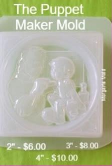 Clear plastic tray mold holding a seated marionette puppet with jointed limbs inside an oval frame