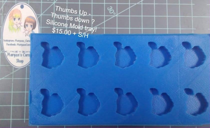 Tray mold with ten identical cavities, each a closed fist with the thumb sticking out.