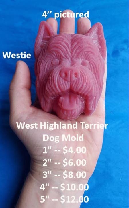Pink cast of a West Highland terrier head mold held in a hand, with shaggy fur and pricked ears.