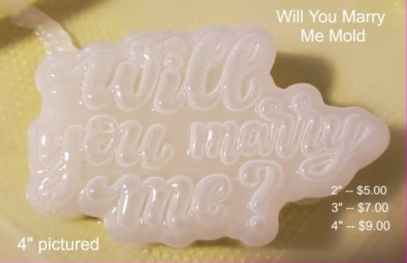 Pale pink mold cut to the words Will you marry me? in three lines of thick rounded script.