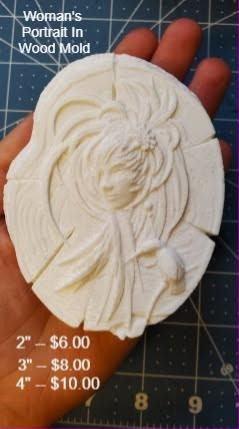 Cream cast round wood slice with a woman's face and long wavy hair carved into the grain